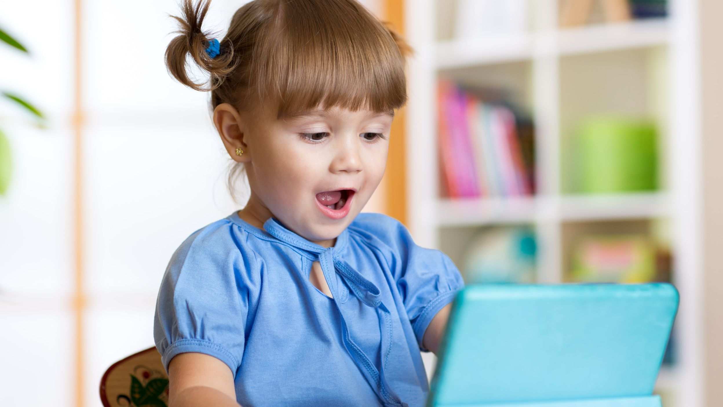 Surprised girl looking at a toy laptop