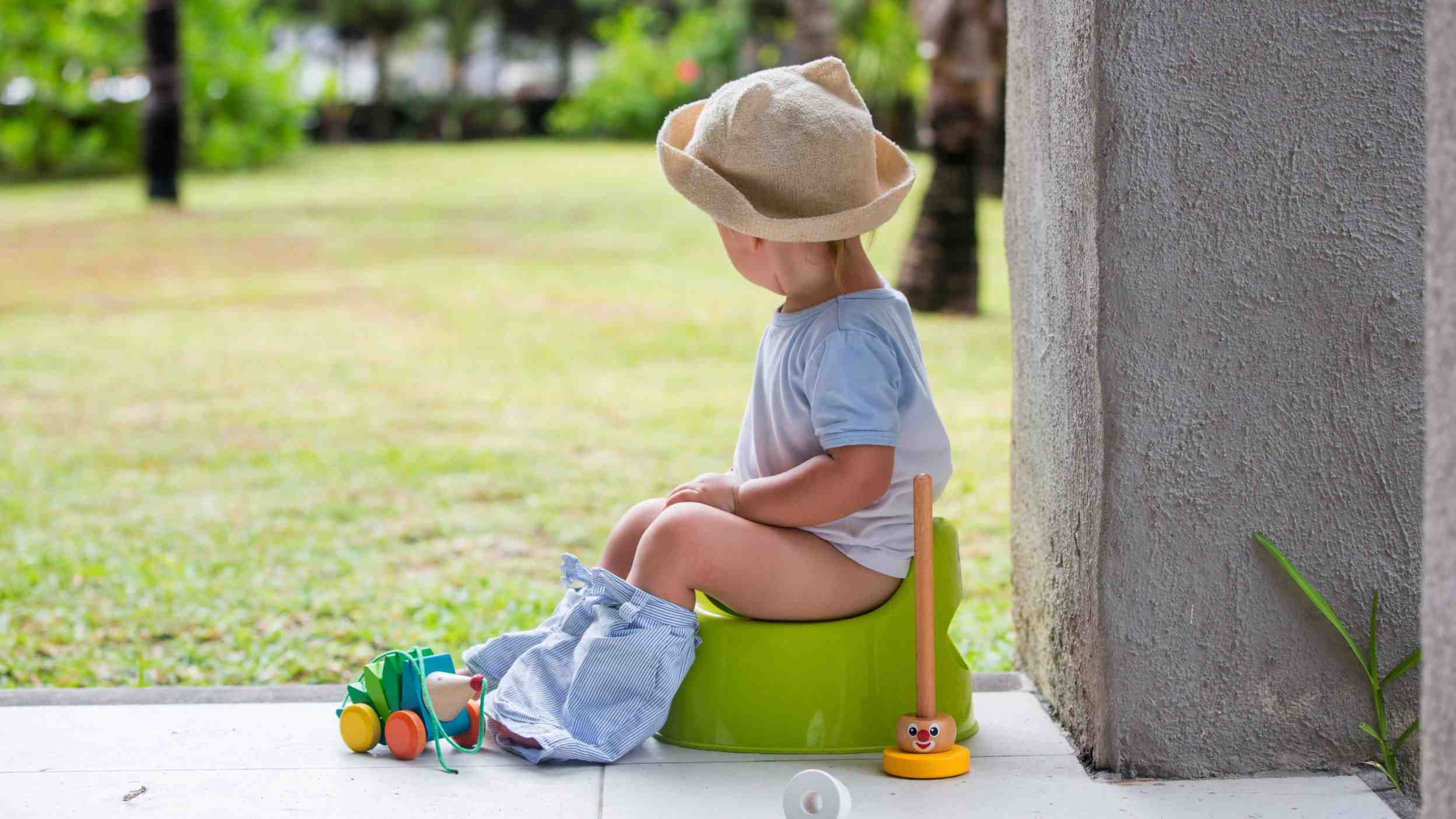 Toddler sitting on a potty outdoors