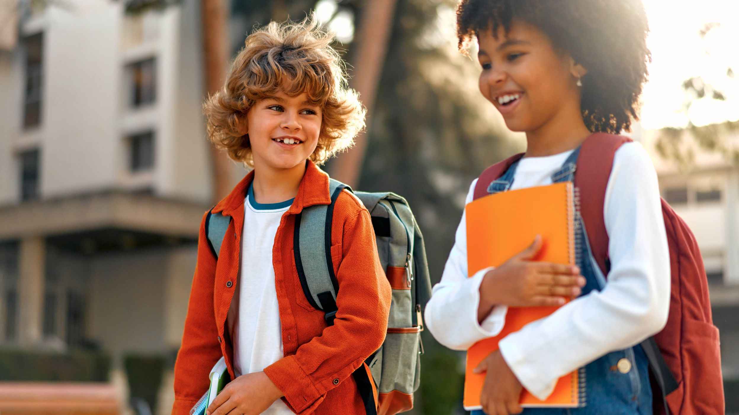 Two smiling school children walking side by side