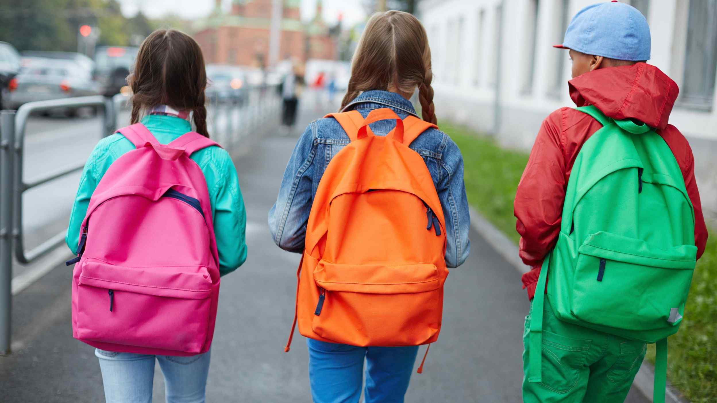 School friends with backpacks walking side by side