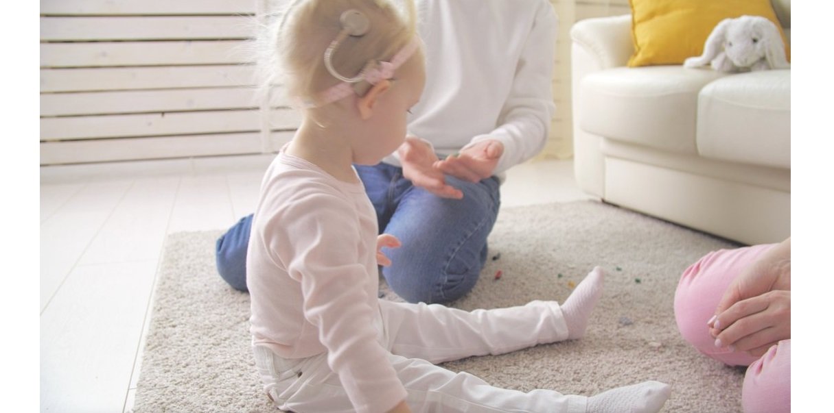 A special needs toddler sitting on a rug